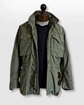 Men's durable utility field jacket designed for outdoor activities, featuring multiple pockets for storage and a rugged, weather-resistant fabric suitable for various environments. 0