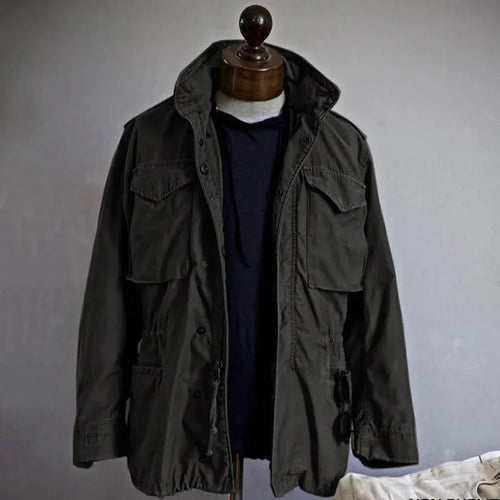 Men's durable utility field jacket designed for outdoor activities, featuring multiple pockets for storage and a rugged, weather-resistant fabric suitable for various environments. 1